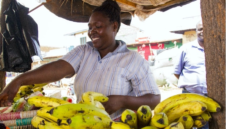 Woman smiling, Selling Banana's on a stall