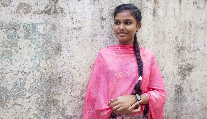 Profile Photo of young women standing against a wall.