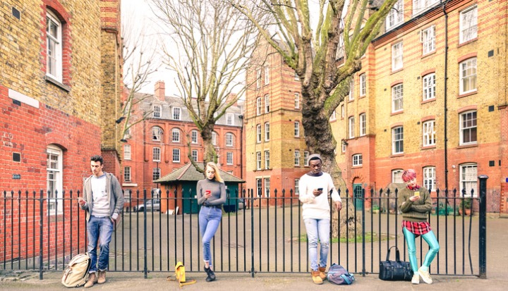 digital divide social mobility - Multiracial people group and urban friends using mobile phone
