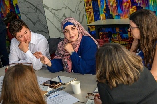 People participating in a roundtable discussion around a conference table